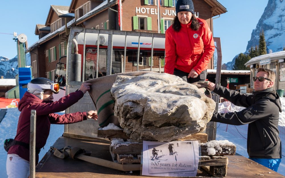 100 Jahre Slalom – ein Gedenkstein für Mürren Erika Hess (links), Rachel Arkin (Tourismusdirektorin von Mürren) und Will Lunn (Urenkel von Arnold Lunn) nehmen den Gedenkstein in Empfang. – Foto: Jungfrau Region Tourismus AG