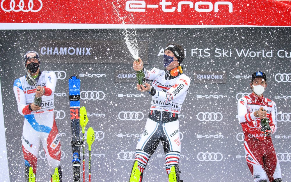 Clement Noel (Mitte) freut sich über den Sieg in Chamonix und zum Regen gesellt sich die Champagner-Dusche dazu. – Foto: GEPA pictures