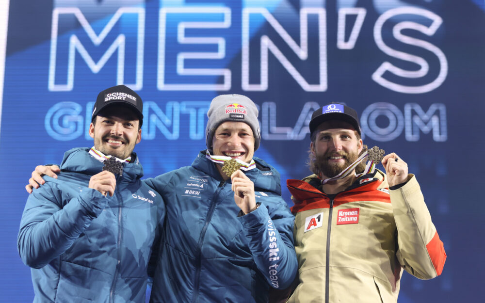 Marco Odermatt holt sein zweites WM-Gold Loic Meillard, Marco Odermatt und Marco Schwarz mit dem Lohn für die Arbeit – den Medaillen. – Foto: GEPA pictures